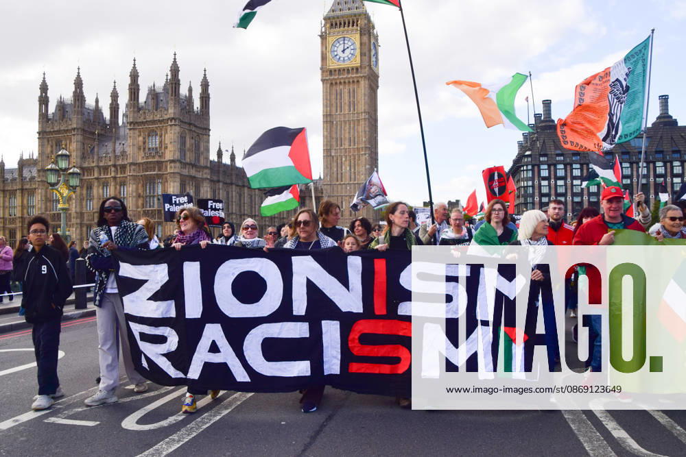 Protesters hold a Zionism is racism banner as they pass over Westminster Bridge past the Houses of Parliament during the National March for Palestine. Thousands of people marched in Central London marking three years of what the protest organisers call the genocide against the Palestinian people in Gaza London United Kingdom - ZUMAv130 20261010_zip_v130_074