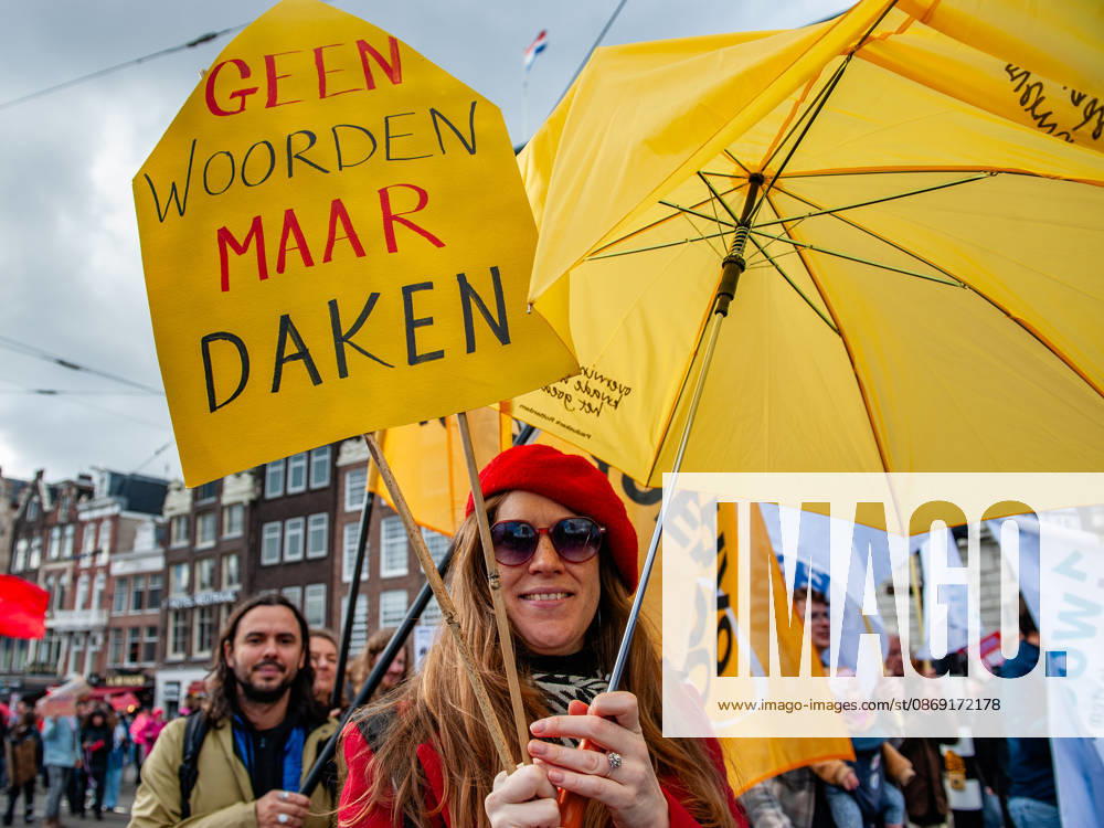 A protester is holding a yellow placard that says No words, but roofs during the demonstration. People gathered against the worsening housing crisis. Under the motto Houses for people, not for profit, they demand fundamental changes in Dutch public housing. Amsterdam Netherlands - ZUMAs197 20261010_aaa_s197_550