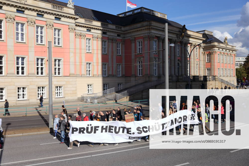 Protesters march with a banner reading Review today, Schütz tomorrow at the state parliament during a demonstration calling for the Federal Constitutional Court to review far-right parties, Potsdam, October 10, 2026. Review demonstration in Potsdam