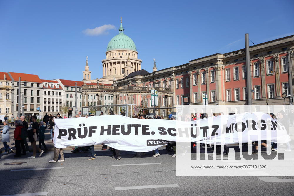 Protesters march with a banner reading Review today, Schütz tomorrow at the state parliament during a demonstration calling for the Federal Constitutional Court to review far-right parties, Potsdam, October 10, 2026. Review demonstration in Potsdam