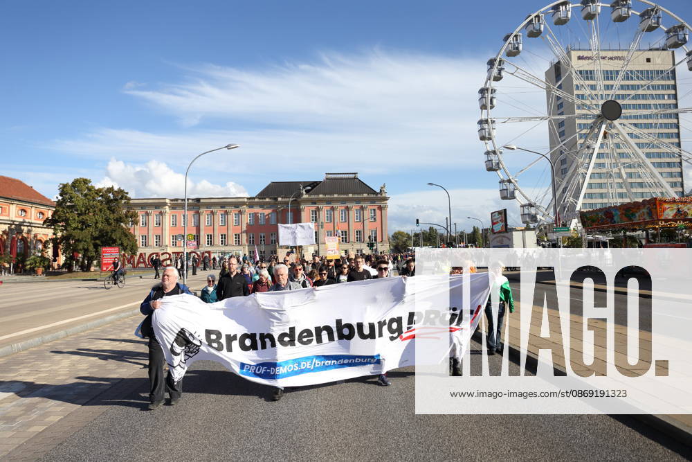 Protesters walk down Breite Straße carrying a banner reading Brandenburg: Investigate during a demonstration calling for the Federal Constitutional Court to review far-right parties, Potsdam, October 10, 2026. Investigate demonstration in Potsdam