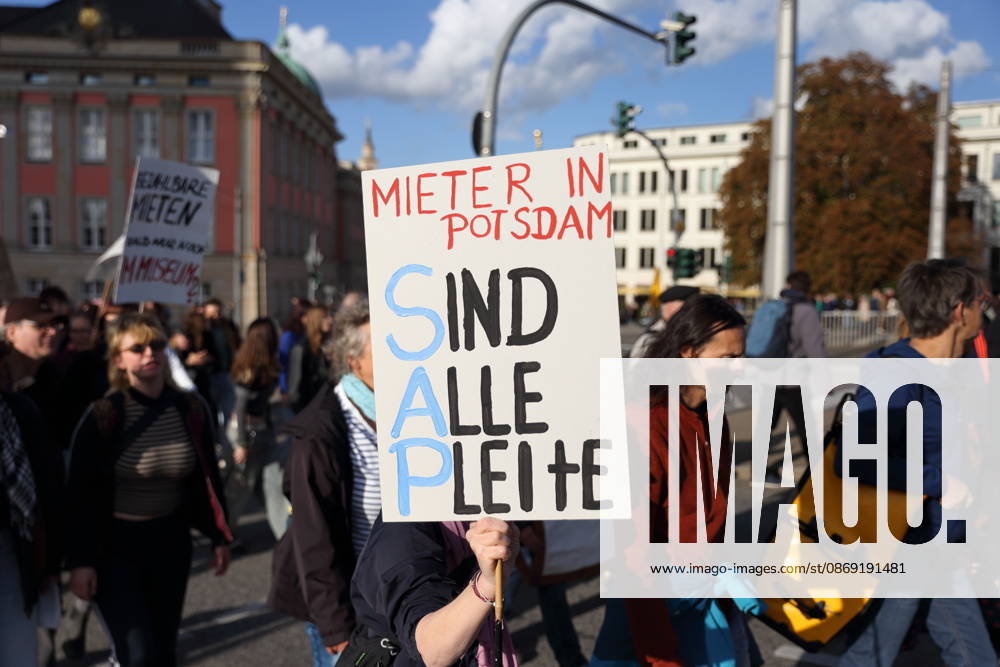 A protester walks across the Lange Brücke in Potsdam carrying a sign that reads Tenants: Are We All Broke? during a demonstration against the housing crisis and rising rents, Potsdam, October 10, 2026. Rent Protest in Potsdam