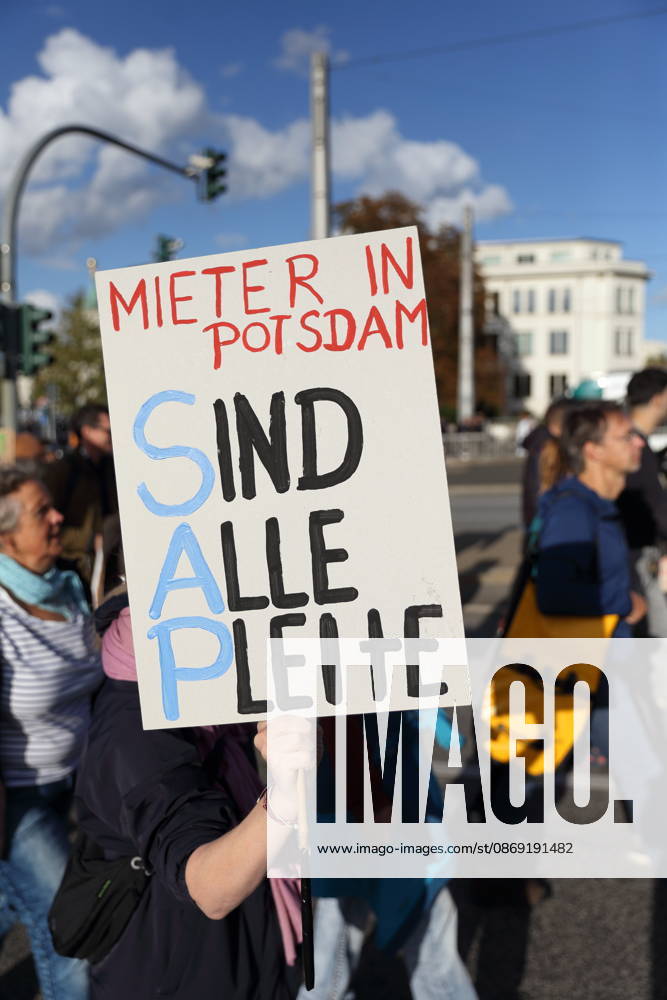 A protester walks across the Lange Brücke in Potsdam carrying a sign that reads Tenants: Are We All Broke? during a demonstration against the housing crisis and rising rents, Potsdam, October 10, 2026. Rent Protest in Potsdam