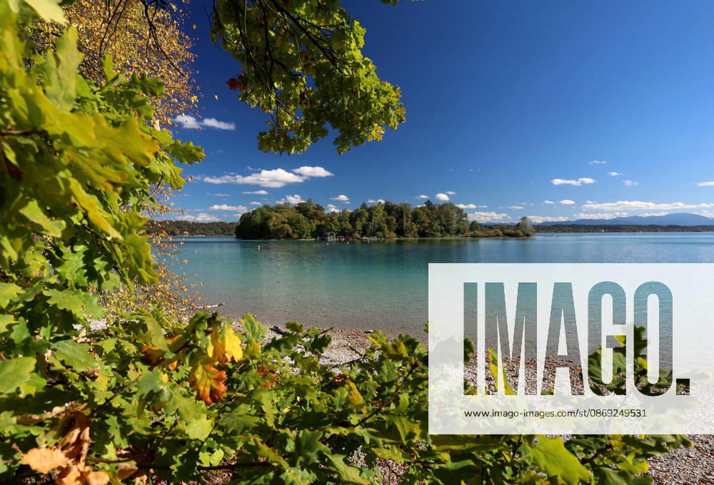 An autumn day in Feldafing, Feldafinger Park, Starnberg District. Here is a view of Lake Starnberg with Rose Island and colorful trees, foliage colors, deciduous trees, autumnal, play of colors, autumn leaves, autumn colors, leaf coloration, red, yellow, red foliage, yellow foliage, natural spectacle, autumn scene, autumn impression, weather scene, golden October