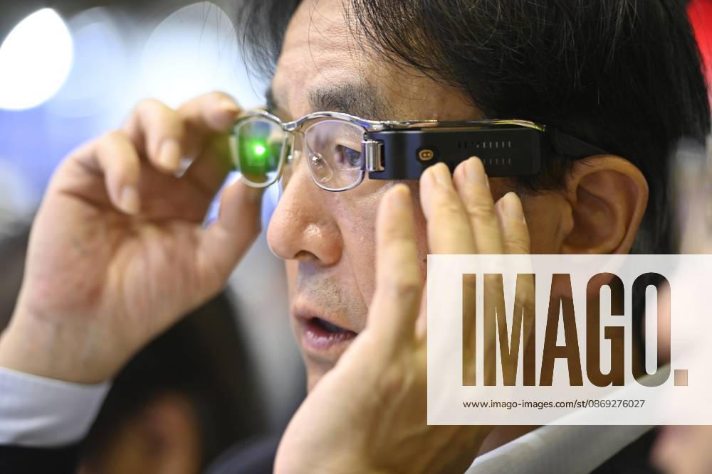 Japan showcases emerging technologies at CEATEC 2026 CHIBA, JAPAN - OCTOBER 13: A visitor tries on a prototype of smart glasses featuring Meta-Optic Mirror technology developed by Japanese electronics company TDK during CEATEC 2026 at Makuhari Messe in Chiba, Japan, October 13, 2026. The prototype uses an ultra-thin optical mirror to direct projected images onto the retina, with TDK aiming to develop more compact and conventional-looking smart glasses. David Mareuil Anadolu Chiba Japan. Editorial use only. Please get in touch for any other usage.
