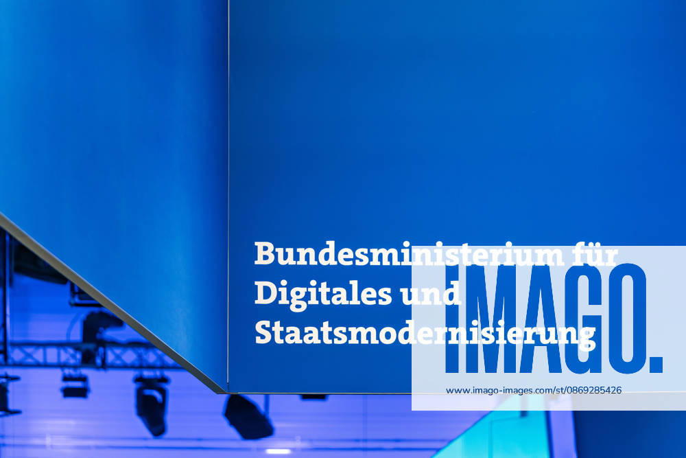 Berlin, 13.10.2026: Der Schriftzug Bundesministerium für Digitales und Staatsmodernisierung an einem blauen Deckenaufbau über dem Messestand des Ministeriums auf der Smart Country Convention. Das 2025 gegründete Ministerium unter Karsten Wildberger soll die Digitalisierung des Staates bündeln. Die Smart Country Convention (SCCON) ist die Kongressmesse für die Digitalisierung des öffentlichen Sektors und wird vom Digitalverband Bitkom gemeinsam mit der Messe Berlin veranstaltet. Vom 13. bis 15. Oktober 2026 treffen sich auf dem Berliner Messegelände Vertreter aus Bund, Ländern und Kommunen mit Unternehmen der Digitalwirtschaft, um über digitale Verwaltung, Smart City und digitale Souveränität zu diskutieren. Schriftzug des B