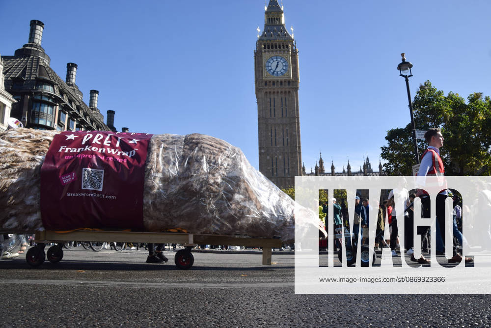 Protesters pass through Parliament Square with a giant wrapped chicken during the march to Pret headquarters urging the fast food chain to drop Frankenchickens. Frankenchickens are chickens mostly raised on factory farms who are bred to grow much faster and who are said to suffer far more than regular chickens. London United Kingdom - ZUMAv130 20261013_zip_v130_025