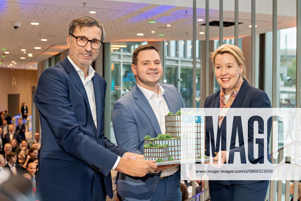 Berlin, 13.10.2026: DKB-CEO Dr. Sven Deglow (l.) und Berlins Bürgermeisterin und Senatorin für Wirtschaft, Energie und Betriebe, Franziska Giffey (SPD) (r.), halten bei der Eröffnungsfeier im Foyer des neuen DKB-Campus in der Europacity in Berlin-Mitte gemeinsam mit einem weiteren Gast (M.) eine Torte in Form des neuen Gebäudes mit DKB-Schriftzug. Die Deutsche Kreditbank AG (DKB) hat ihren neuen Hauptsitz heute offiziell eröffnet. Der von Kleihues + Kleihues entworfene, rund 82 Meter hohe Komplex besteht aus drei Gebäudeteilen mit fünf, elf und 19 Geschossen und rund 35.000 Quadratmetern Mietfläche; entwickelt wurde er von der CA Immo unter dem Projektnamen Upbeat. Rund 2.600 Mitarbeitende des DKB-Konzerns, die bislang auf meh