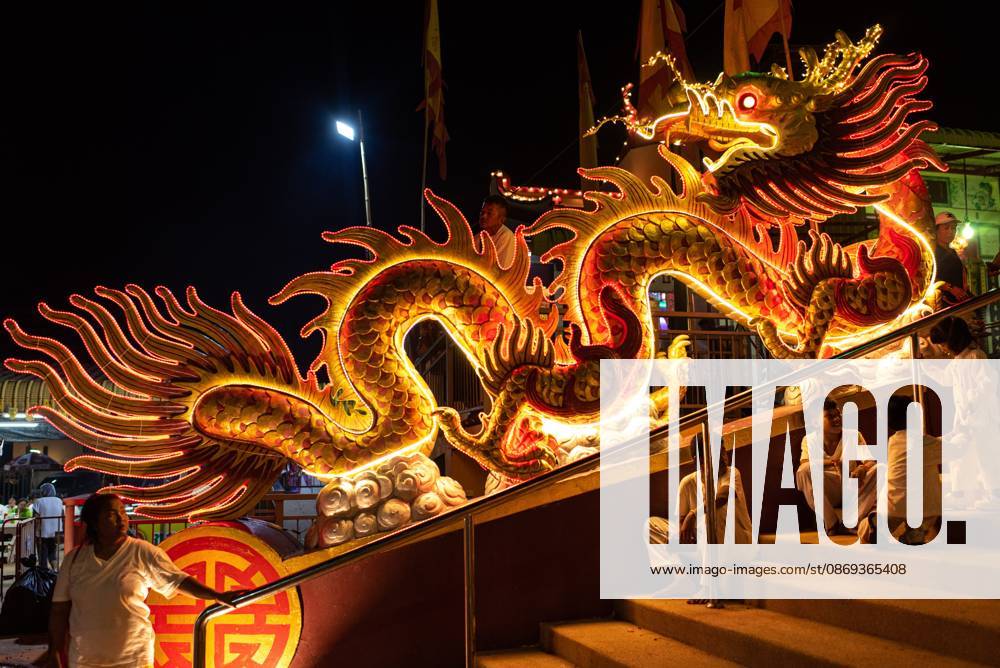 The vegetarian festival in Trang, Thailand. – 13 Oct 2026 Devotees sit next to the illuminated dragon at the Chinese shrine during the Vegetarian Festival. The annual Vegetarian Festival is held in Bangkok and many parts of southern Thailand, including Trang, Phatthalung, and Phuket, where worshippers refrain from eating animal products over the nine days, coinciding with the celebration of the Nine Emperor Gods. Trang Thailand