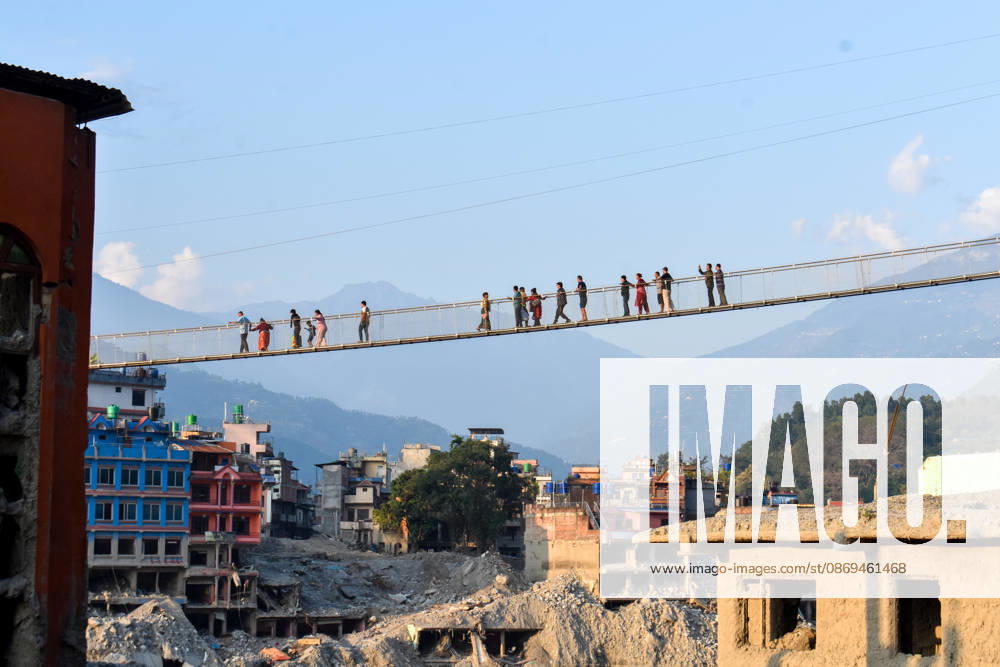 Aftermath of flash floods in Nepal NUWAKOT, NEPAL - OCTOBER 14 : People walk across a newly built suspension bridge over the Trishuli River, Nuwakot district, Nepal on October 14, 2026. Road and pedestrian connectivity has been restored with the construction of a new suspension bridge over the Trishuli River, allowing local residents to cross the river after the devastating floods damaged bridges and other infrastructure in the area. Sunil Pradhan Anadolu Nuwakot Nepal. Editorial use only. Please get in touch for any other usage.