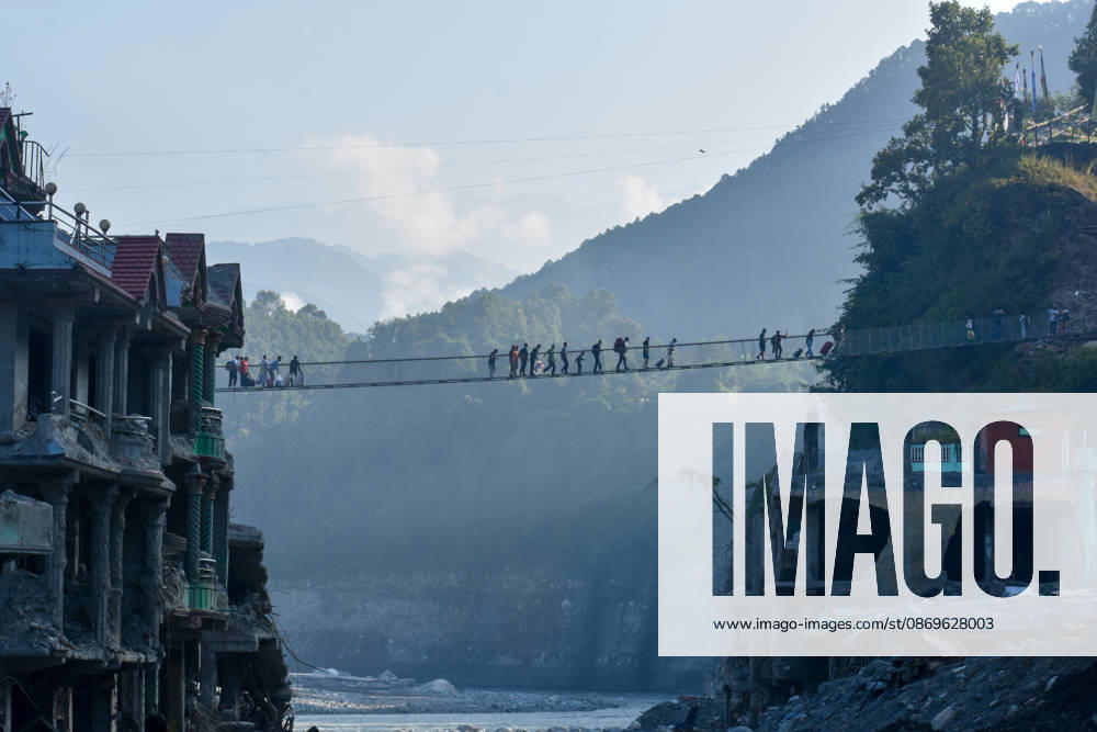 Local residents cross the newly installed Bailey bridge connecting the border areas of Nuwakot and Rasuwa districts on October 15, 2026 in Nuwakot, Nepal. The bridge was installed to restore road connectivity after severe flooding destroyed existing bridges on August 26, 2026.