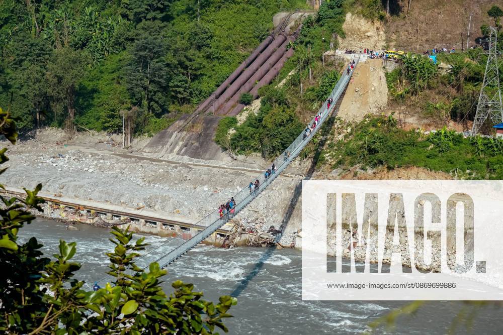 New Bridge Restores Nuwakot Crossing NUWAKOT, NEPAL, OCTOBER 15, 2026: People cross a newly built suspension bridge over the Trishuli River in Bidur Municipality, Nuwakot District. The footbridge restores access between communities after flooding along the Bhotekoshi Trishuli river corridor swept away road bridges and disrupted local transport. NUWAKOT bagmati Nepal