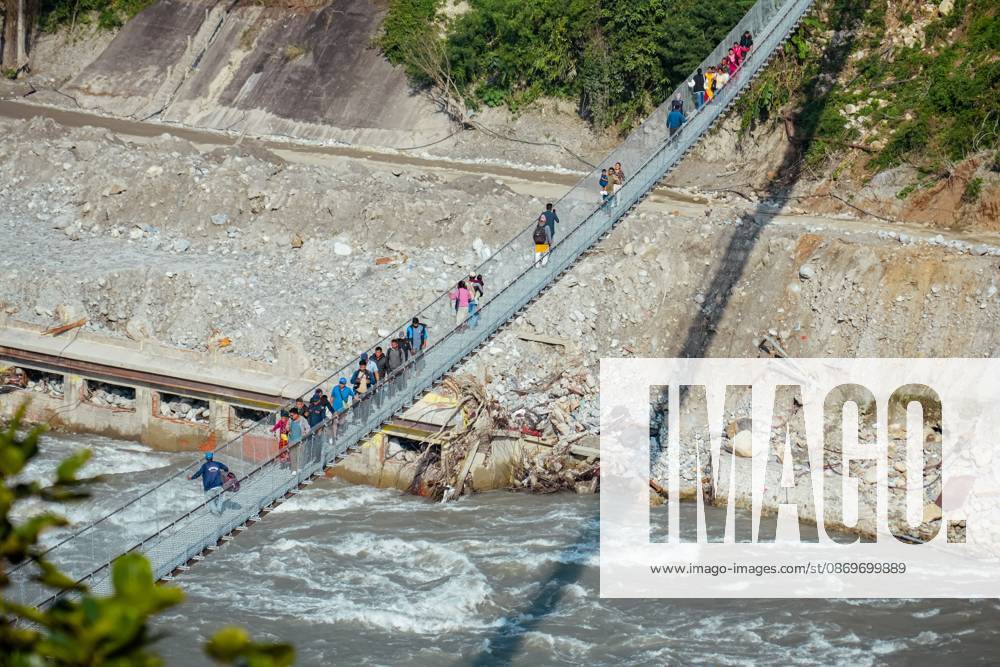 New Bridge Restores Nuwakot Crossing NUWAKOT, NEPAL, OCTOBER 15, 2026: People cross a newly built suspension bridge over the Trishuli River in Bidur Municipality, Nuwakot District. The footbridge restores access between communities after flooding along the Bhotekoshi Trishuli river corridor swept away road bridges and disrupted local transport. NUWAKOT bagmati Nepal