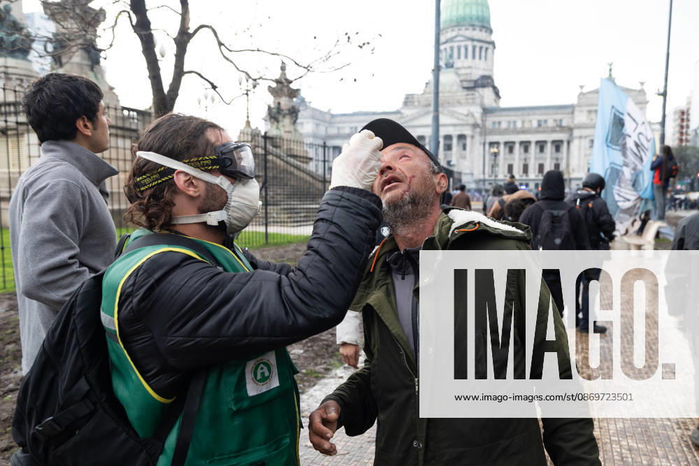 Medical staff treat an injured man affected by tear gas during clashes with police. Buenos Aires Argentina - ZUMAp265 20261016_zip_p265_051