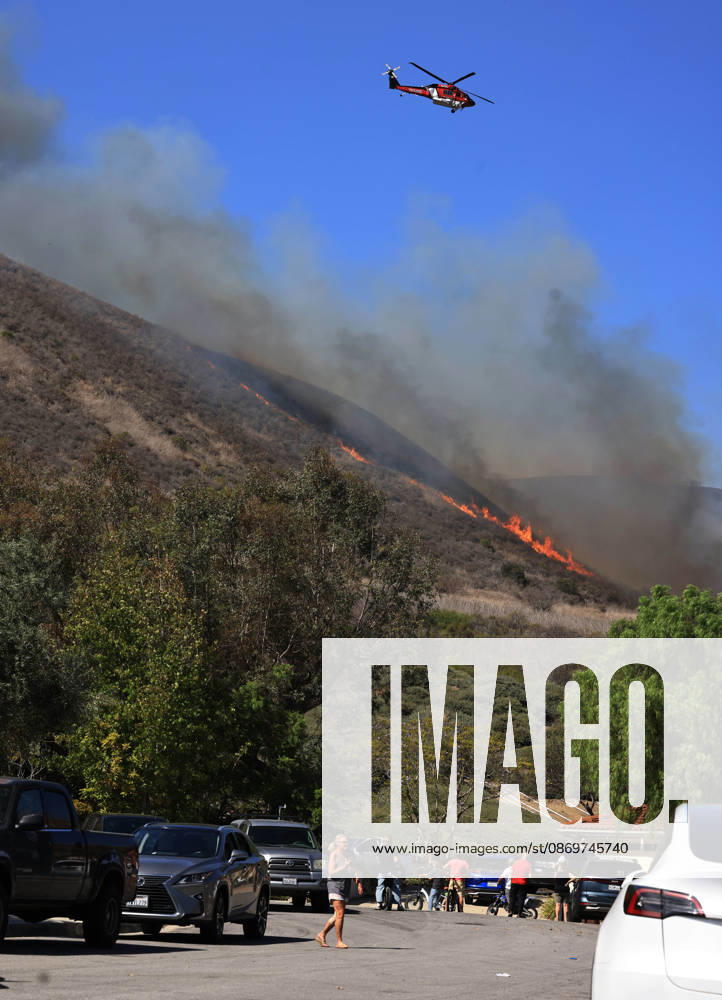 October16, 2026, San Juan Capistrano, California, USA: Fire crews are aggressively battling a wind-driven brush fire that burned several homes and threatened thousands of others in the area of San Juan Capistrano and San Clemente Friday, prompting evacuation orders. The Norte Fire exploded to 465 acres and remains 0 percent contained as of 4 p.m. O.C. Fire Authority officials said the Norte Fire started around 11:30 a.m. near Portico Del Norte and Eminencia Del Norte in San Clemente, east of Interstate 5. Fueled by strong Santa Ana winds, the wildfire then blew into neighboring San Juan Capistrano. San Juan Capistrano USA - ZUMAr19_ 20261016_new_r19_171