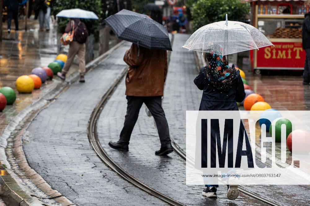 Pedestrians with umbrellas walk along wet tram tracks in Istanbul, Turkey. Istanbul faces another round of heavy rain after floods that left five people dead, with orange alerts in place and downpours expected to intensify, according to ToÂ¼rkiye Today. Istanbul Turkey - ZUMAz174 20261017_zip_z174_004