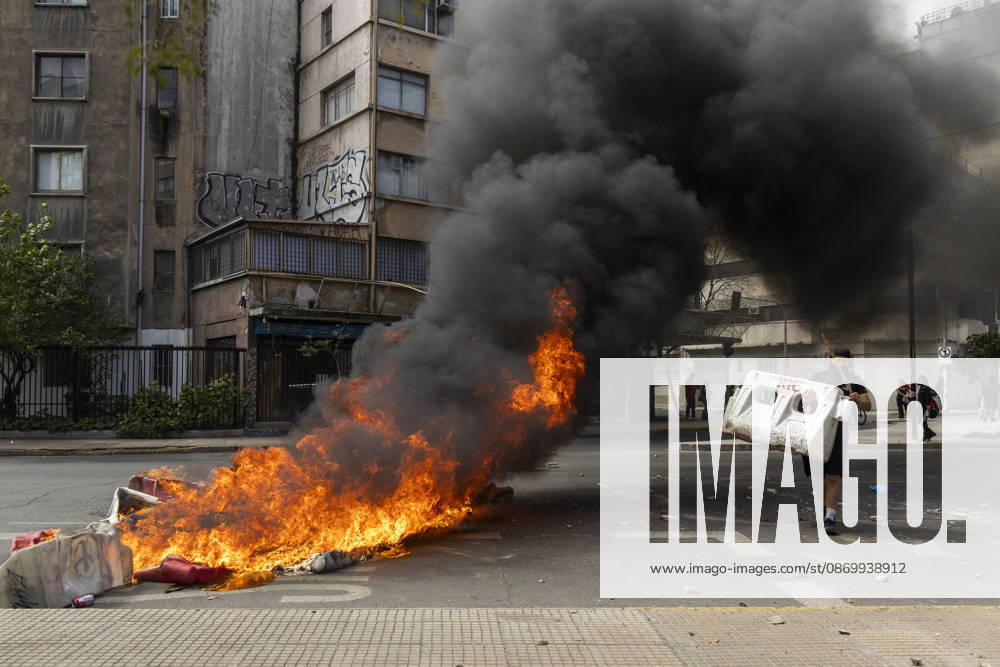 A man walks past a burning barricade during the demonstration. In the center of the capital of Chile, different incidents took place between demonstrators and the police. The riots were carried out during the commemoration of the 7 years after the social outcast that happened on October 18, 2019. Santiago Chile - ZUMAs197 20261019_aaa_s197_002