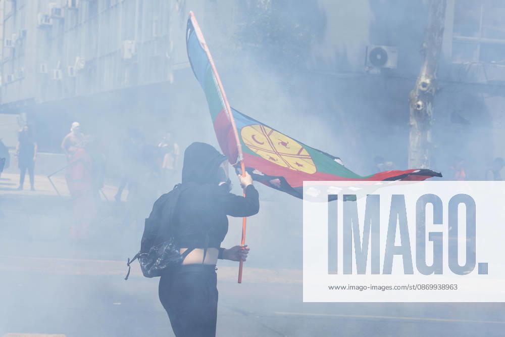 A demonstrator in the smoke flies a flag that symbolizes the Mapuche people. In the center of the capital of Chile, different incidents took place between demonstrators and the police. The riots were carried out during the commemoration of the 7 years after the social outcast that happened on October 18, 2019. Santiago Chile - ZUMAs197 20261019_aaa_s197_004