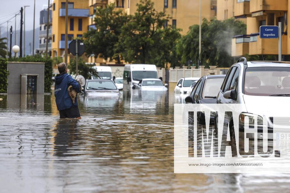 The Valencian Regional Government is preparing a lockdown order for the southern coast of Valencia and the northern coast of Alicante due to the rains. A man walks through a flooded area with a dog on October 19, 2026, in Guardamar de la Safor, Valencia, Valencian Community, Spain. The Valencian Regional Government is preparing a lockdown order for the southern coast of Valencia and the northern coast of Alicante in response to the emergency declared due to the rains brought by Storm Adam, as announced by the Regional Minister of Emergencies and the Interior early this morning, October 19, from the Emergency Coordination Center (CCE) October 19, 2026, Valencia, Valencian Community, Spain