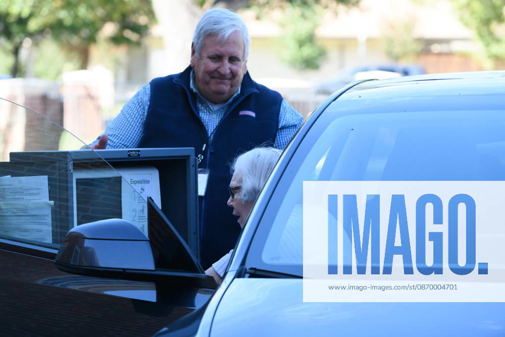 Early voting started in Dallas TX on Monday morning...University Park United Methodist Church..By 1130 am, nearly 700 people voted at this location..Election worker helps a citizen vote curbside. Dallas USA - ZUMAa183 20261019_znp_a183_023