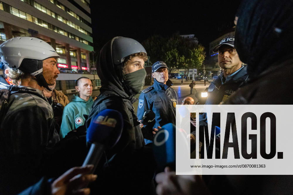 Police officers speak with protesters during the clearance of the housing protest camp at Praca D. Joao I. The operation proceeded without major incidents or reports of violence. Porto Portugal - ZUMAs197 20261020_aaa_s197_037