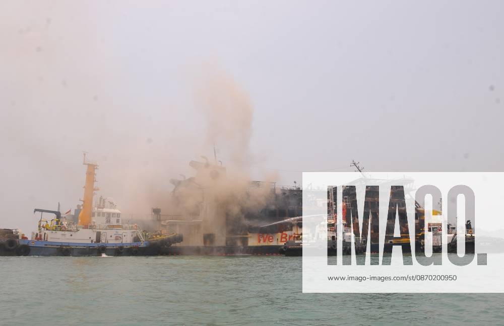 Efforts are underway to extinguish a fire that broke out on a passenger ferry in Indonesia s Cilegon PELABUHAN MERAK, CILEGON, INDONESIA - OCTOBER 21: Fireboats take turns spraying water onto the passenger ferry KMP Batumandi to cool down the vessel after it caught fire while preparing to dock off Merak Port in Cilegon, Banten, Indonesia on Wednesday, October 21, 2026. The vessel caught fire on Tuesday, October 20, and rescue operations remain underway as the ship continues to emit smoke. Water is continuously sprayed to cool the vehicle deck containing numerous cars, motorcycles, buses, and trucks, while authorities confirm no fatalities have been reported. Dasril Roszandi Anadolu Pelabuhan Merak Indonesia. Editorial use only. Please get