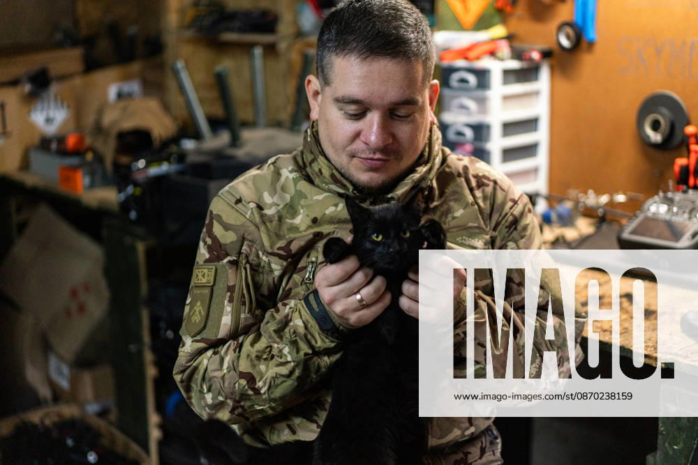 Ukrainian drone unit Skymonsters upgrades heavy UAVs in Kharkiv region KHARKIV REGION, UKRAINE - OCTOBER 21: A serviceman plays with a cat as members of Skymonsters, the drone unit of the 13th Khartiia Brigade of Ukraine s National Guard, assemble, upgrade, and repair large unmanned aerial vehicles at an undisclosed location in Kharkiv region, Ukraine, on October 21, 2026. The drones, including Vampire models used for logistics missions and heavy bombers capable of carrying 13 to 20 kilograms of explosives, are prepared here before deployment to frontline positions. Carlo Bravo Anadolu Kharkiv Ukraine. Editorial use only. Please get in touch for any other usage.