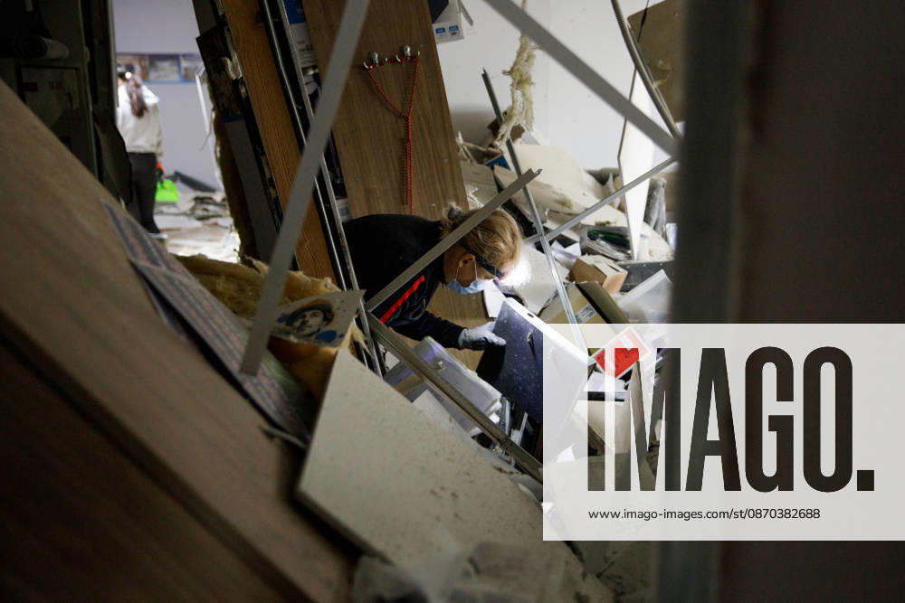 A woman in a surgical mask and a headlight looks for goods that can be salvaged after a Russian attack in an Epicentr K home improvement hypermarket in the Obolonskyi district, Kyiv, Ukraine, October 22, 2026. On Thursday night, Russian forces struck the Ukrainian capital with ballistic missiles and drones. According to the Kyiv City Military Administration, six districts came under attack. One person was killed, 24 were injured, and 16 of them were hospitalised. (Photo by Marianna Kotyk Ukrinform) Russian attack destroys shops in Kyiv