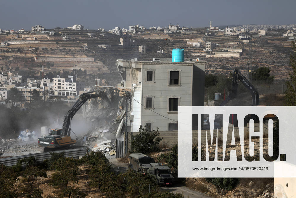 Israeli forces demolish a building in West Bank city of Hebron HEBRON, WEST BANK, PALESTINE - OCTOBER 23: Israeli military heavy machinery demolishes a building during a raid in the West Bank city of Hebron, Palestine, on October 23, 2026. The Israeli military announced earlier in the morning that two of its soldiers were killed during armed clashes with Palestinians, triggering a large-scale military operation and structural demolition in the city. Mamoun Wazwaz Anadolu Hebron West Bank. Editorial use only. Please get in touch for any other usage.