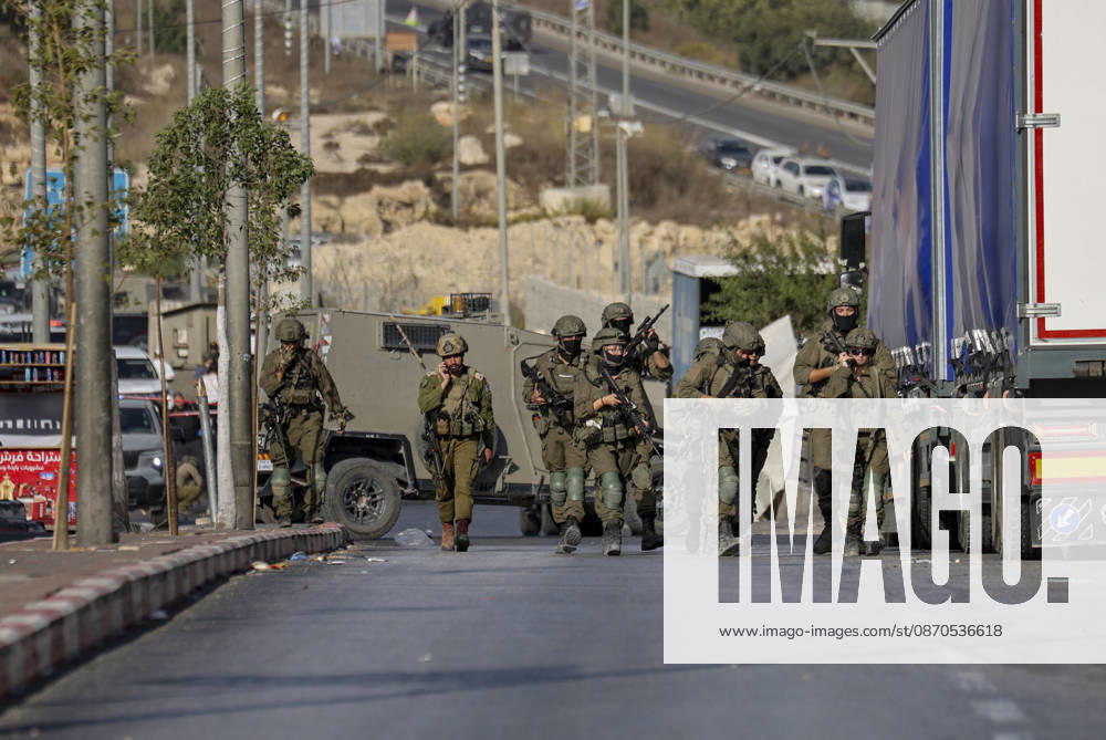 Hebron West Bank Shooting Attack Israeli military forces walk down the road at the entrance to Farsh al-Hawa near Hebron, in the occupied West Bank on October 23, 2026. Journalists were targeted and the area was declared a closed military zone following a Palestinian shooting attack targeting an Israeli military checkpoint at the entrance to Farsh al-Hawa in Hebron. Hebron West Bank Palestinian Territories