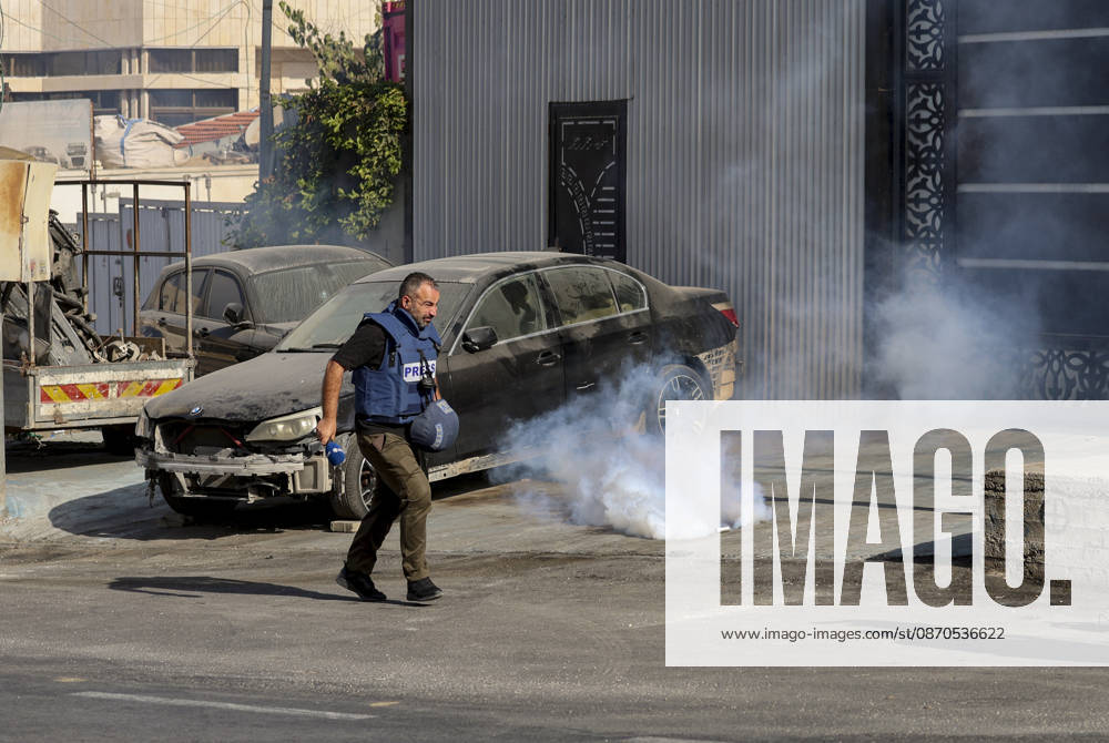 Hebron West Bank Shooting Attack A journalist runs away as tear gas disperses near Farsh al-Hawa in Hebron, in the occupied West Bank on October 23, 2026. Journalists were targeted and the area was declared a closed military zone following a Palestinian shooting attack targeting an Israeli military checkpoint at the entrance to Farsh al-Hawa in Hebron. Hebron West Bank Palestinian Territories