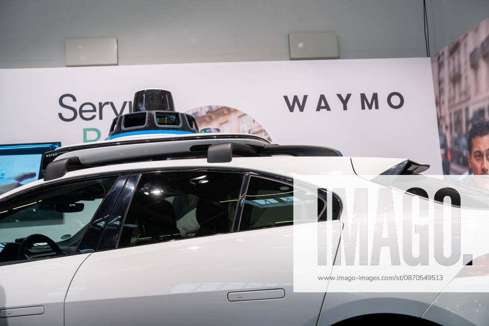 Munich, Bavaria, Germany October 23, 2026: The 2026 convention of the CSU (Christian Social Union) party at the Munich Trade Fair Center. Background image: a close-up of a white Jaguar I-PACE equipped with autonomous driving technology from the U.S. company Waymo. The electric vehicle is equipped with cameras, LiDAR, and radar sensors for AI-assisted detection of its surroundings and is designed for use as a self-driving robotaxi