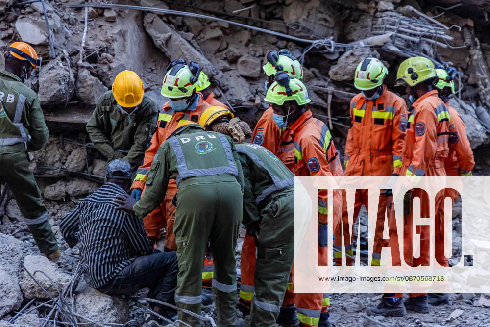 Rescue workers comfort a member of the public near the site of a collapsed multi-storey building under construction in Eastleigh as search and rescue operations continue. Rescuers from multiple emergency response agencies conduct search and rescue operations at the site of a collapsed multi-storey building under construction in Eastleigh, Nairobi, Kenya. An unconfirmed number of people are feared trapped beneath the rubble. Nairobi Kenya - ZUMAs197 20261023_aaa_s197_300