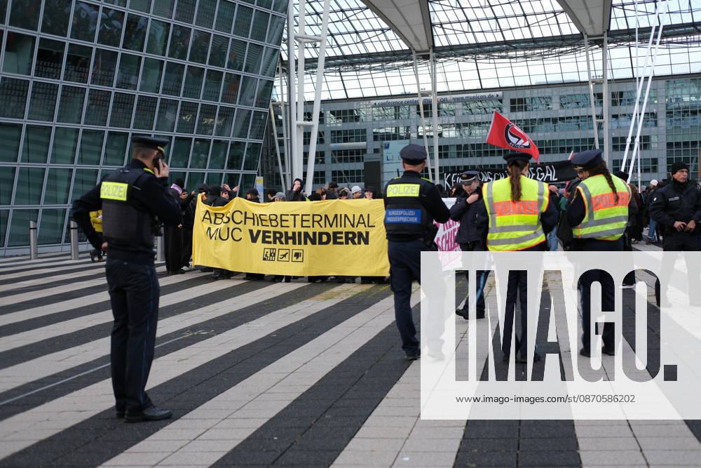 Protest at Munich Airport against planned deportation terminal MUNICH, GERMANY - OCTOBER 24: Police officers stand in front of protesters holding a yellow banner reading Abschiebeterminal MUC verhindern (Stop the MUC Deportation Terminal) during a demonstration outside the MAC Forum at Munich Airport in Munich, Germany on October 24, 2026. The rally targets a planned deportation terminal that Germany s federal government intends to operate at the airport from 2028. Merve Goettl Anadolu Munich Germany. Editorial use only. Please get in touch for any other usage.