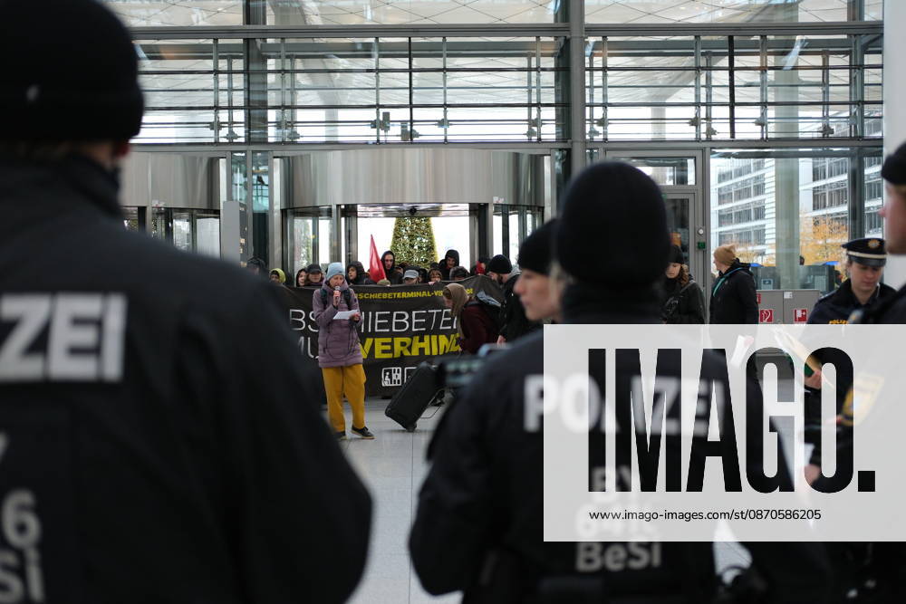 Protest at Munich Airport against planned deportation terminal MUNICH, GERMANY - OCTOBER 24: Police officers stand facing protesters holding a banner reading Abschiebeterminal muss verhindert werden (Deportation terminal must be prevented) inside the MAC Forum at Munich Airport in Munich, Germany on October 24, 2026. The demonstration targets a planned deportation terminal that Germany s federal government intends to operate at the airport from 2028. Merve Goettl Anadolu Munich Germany. Editorial use only. Please get in touch for any other usage.