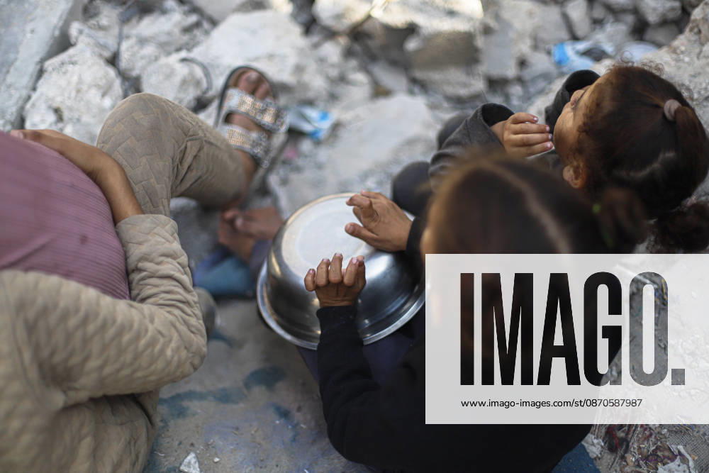 Gaza Palestinians Food Shortages 2026 Palestinian children sit together among the rubble of destroyed buildings while waiting near a food distribution point in Jabalia Refugee Camp, northern Gaza Strip, Palestine, on October 24, 2026. The UN reports that damaged infrastructure, displacement and shortages of basic supplies continue to affect residents of Gaza, while funding shortages have reduced food assistance. Jabalia Gaza Strip Palestinian Territories
