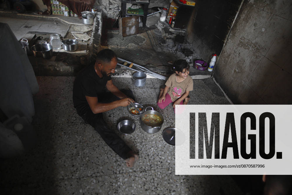 Gaza Palestinians Food Shortages 2026 A Palestinian man and a young child sit on the floor of a damaged home to eat beside metal bowls and cooking pots in Jabalia Refugee Camp, northern Gaza Strip, Palestine, on October 24, 2026. The UN says widespread damage, displacement and food shortages have left families across Gaza heavily dependent on humanitarian assistance, with food distributions reduced in October amid funding constraints. Jabalia Gaza Strip Palestinian Territories