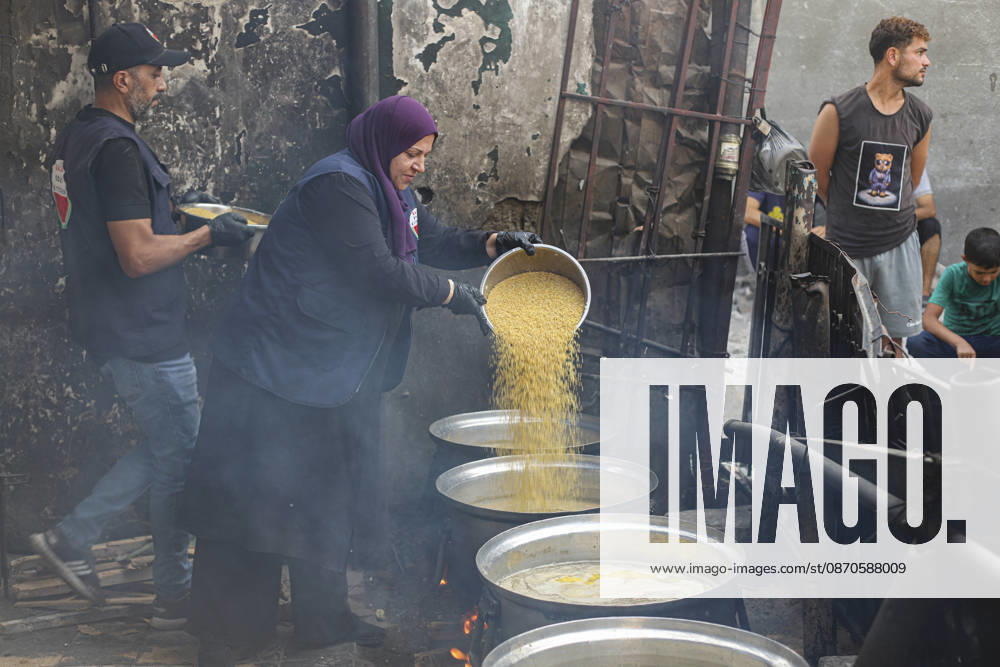 Gaza Palestinians Food Shortages 2026 A woman pours a large quantity of cooked food from one metal vessel into another at a charity kitchen in Jabalia Refugee Camp, northern Gaza Strip, Palestine, on October 24, 2026. Community kitchens remain a key source of food in Gaza, where UN humanitarian agencies reported cuts to cooked-meal distributions in October because of funding shortages. Jabalia Gaza Strip Palestinian Territories