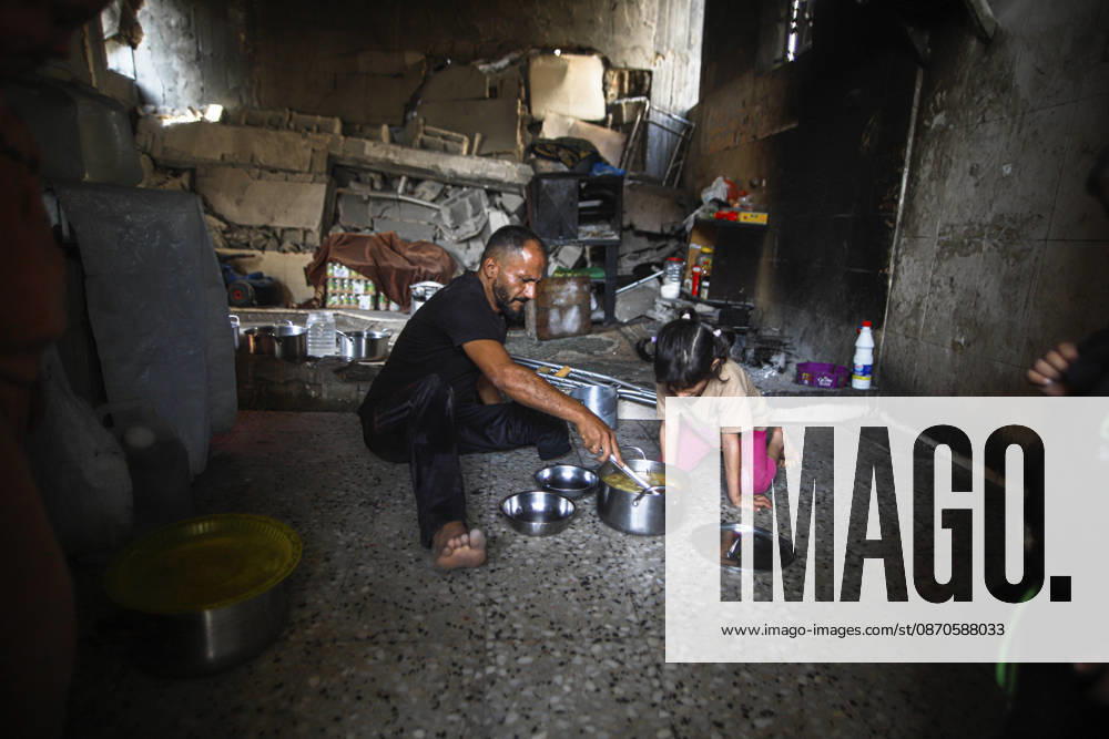 Gaza Palestinians Food Shortages 2026 A Palestinian man and a young child sit on the floor of a damaged home to eat beside metal bowls and cooking pots in Jabalia Refugee Camp, northern Gaza Strip, Palestine, on October 24, 2026. The UN says widespread damage, displacement and food shortages have left families across Gaza heavily dependent on humanitarian assistance, with food distributions reduced in October amid funding constraints. Jabalia Gaza Strip Palestinian Territories