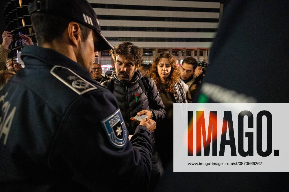 Police officers speak with protesters during the housing protest camp at Praça D. João I. Demonstrators remained at the housing protest camp in Praça D. João I, after voting during a public assembly to continue the occupation beyond the authorized protest period. Police issued repeated warnings before advancing shortly after 3 a.m. with riot police, special intervention units and police dogs to clear the encampment. Protesters formed human chains around the tents and clashes occurred as officers dismantled the camp. Following the operation, demonstrators regrouped at Avenida dos Aliados in front of Porto City Hall, where the protest continued. Porto Portugal - ZUMAs197 20261025_aaa_s197_005