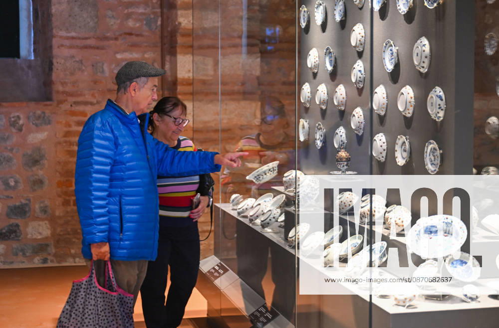 (261025) -- ISTANBUL, Oct. 25, 2026 -- Visitors view Chinese porcelain exhibits at the newly opened Porcelain Museum within the Topkapi Palace in Istanbul, T¨¹rkiye, Oct. 25, 2026. T¨¹rkiye on Saturday inaugurated a new museum district within Istanbul s historic Topkapi Palace, where thousands of Chinese porcelain pieces are on display, reflecting centuries of cultural exchanges between China and T¨¹rkiye. Restored into a historical neighborhood complete with its own streets and squares, the palace s former mint now houses the Porcelain Museum, which displays 5,300 pieces -- including 3,500 Chinese porcelains -- across 19 halls. Dating back to the 13th century, Chinese porcelains -- particularly those from Jingdezhen -- traveled a