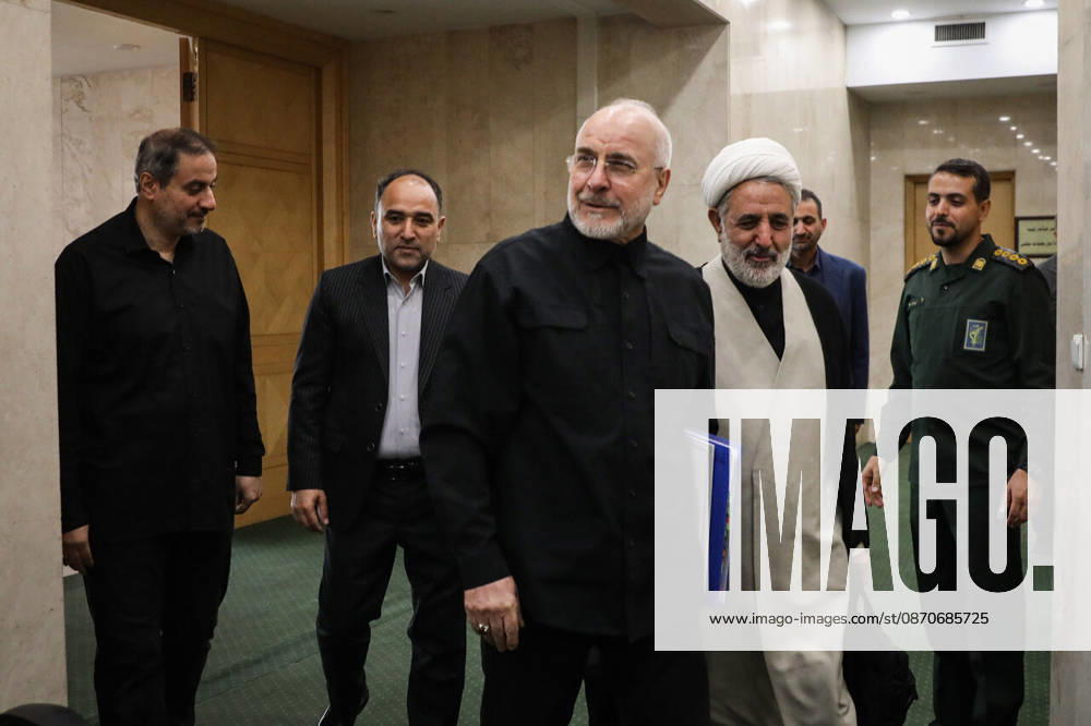 Iranian Parliament Speaker Mohammad Bagher Ghalibaf walks through a corridor carrying a blue folder alongside a white-turbaned cleric and other officials at the Islamic Consultative Assembly in Tehran, Iran, on October 25, 2026. Parliamentary reports said more than two-thirds of lawmakers joined the October 25 open sitting of the Islamic Consultative Assembly, attending either in person or remotely. Tehran Iran - ZUMAi98_ 20261025_zih_i98_034