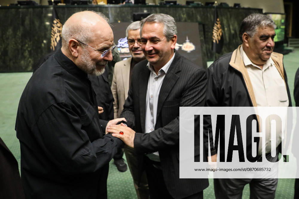 Mohammad Bagher Ghalibaf clasps hands with a smiling man in a dark suit while other officials stand nearby at the Islamic Consultative Assembly in Tehran, Iran, on October 25, 2026. The Iranian parliament held a hybrid open sitting, with some lawmakers attending in the Tehran chamber and others participating remotely, according to parliamentary reports. Tehran Iran - ZUMAi98_ 20261025_zih_i98_037