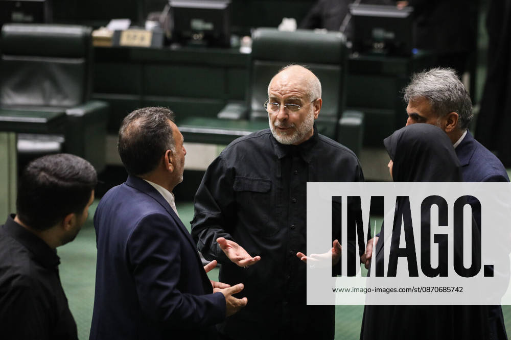 Mohammad Bagher Ghalibaf gestures with open hands while speaking with a suited lawmaker and a woman in a black chador at the Islamic Consultative Assembly in Tehran, Iran, on October 25, 2026. The Islamic Consultative Assembly resumed an open sitting in its Tehran chamber with a mix of in-person and remote participation, according to parliamentary reporting. Tehran Iran - ZUMAi98_ 20261025_zih_i98_044