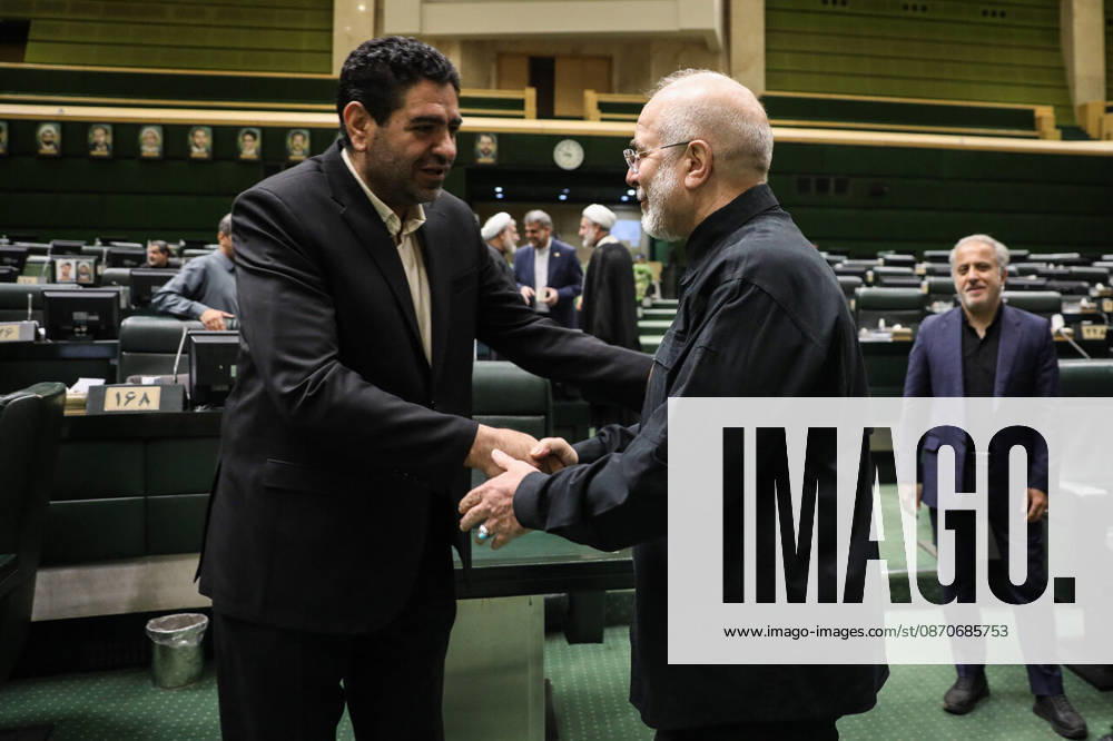 Mohammad Bagher Ghalibaf shakes hands with a tall dark-haired man between rows of parliamentary seats at the Islamic Consultative Assembly in Tehran, Iran, on October 25, 2026. Parliamentary reports said more than two-thirds of lawmakers joined the October 25 open sitting of the Islamic Consultative Assembly, attending either in person or remotely. Tehran Iran - ZUMAi98_ 20261025_zih_i98_050