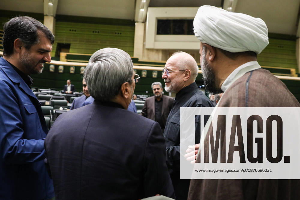 Mohammad Bagher Ghalibaf talks with several suited lawmakers as a cleric in a brown robe stands at the edge of the group at the Islamic Consultative Assembly in Tehran, Iran, on October 25, 2026. The Iranian parliament held a hybrid open sitting, with some lawmakers attending in the Tehran chamber and others participating remotely, according to parliamentary reports. Tehran Iran - ZUMAi98_ 20261025_zih_i98_066