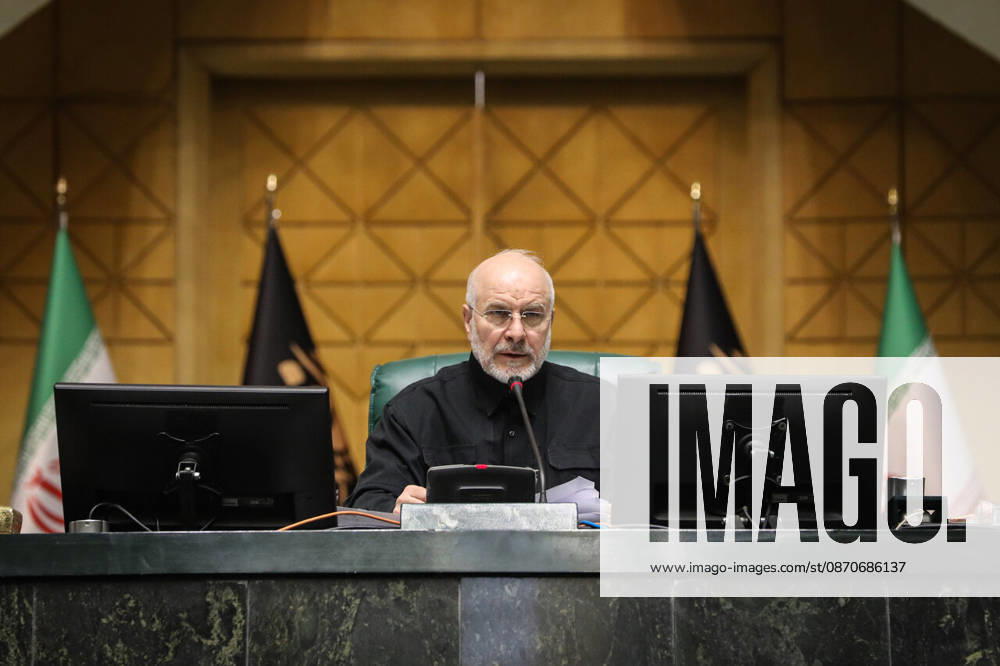 Mohammad Bagher Ghalibaf reads from a page at his desk between Iranian and parliamentary flags at the Islamic Consultative Assembly in Tehran, Iran, on October 25, 2026. The Islamic Consultative Assembly resumed an open sitting in its Tehran chamber with a mix of in-person and remote participation, according to parliamentary reporting. Tehran Iran - ZUMAi98_ 20261025_zih_i98_091