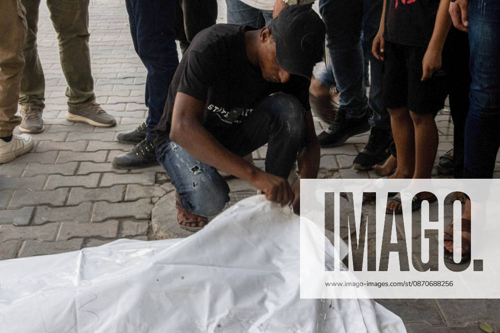 Gaza Israeli University Strike 2026 A Palestinian mourner crouches beside a white body bag while others stand nearby ahead of a funeral in Gaza City, Palestine, on October 25, 2026. According to information provided by local sources, three Islamic University guards, Ashraf Dahlan, Shadi Abu Ataya and Sami Baroud, were killed and others injured in an Israeli strike on the university campus in western Gaza City. Palestinian media reported that a second drone strike hit the campus after an earlier attack injured several people and prompted the university to suspend activities. Gaza Gaza Strip Palestinian Territories