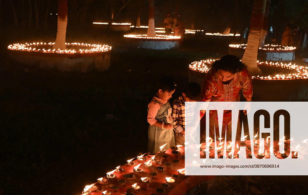 A woman (R) helps her children to light earthen lamp on the occasion of Sharad Purnima (full moon) celebration in Mumbai. Sharad Purnima, also known as the Full Moon Festival, marks the end of the monsoon season. devotees observe fasting and meditate on the full moon night, Goddess Lakshmi, the deity of wealth, is worshipped on this day as it is believed to be her birthday. praying to her is said to bring good luck and prosperity in the life of devotees. Mumbai India - ZUMAs197 20261025_aab_s197_019
