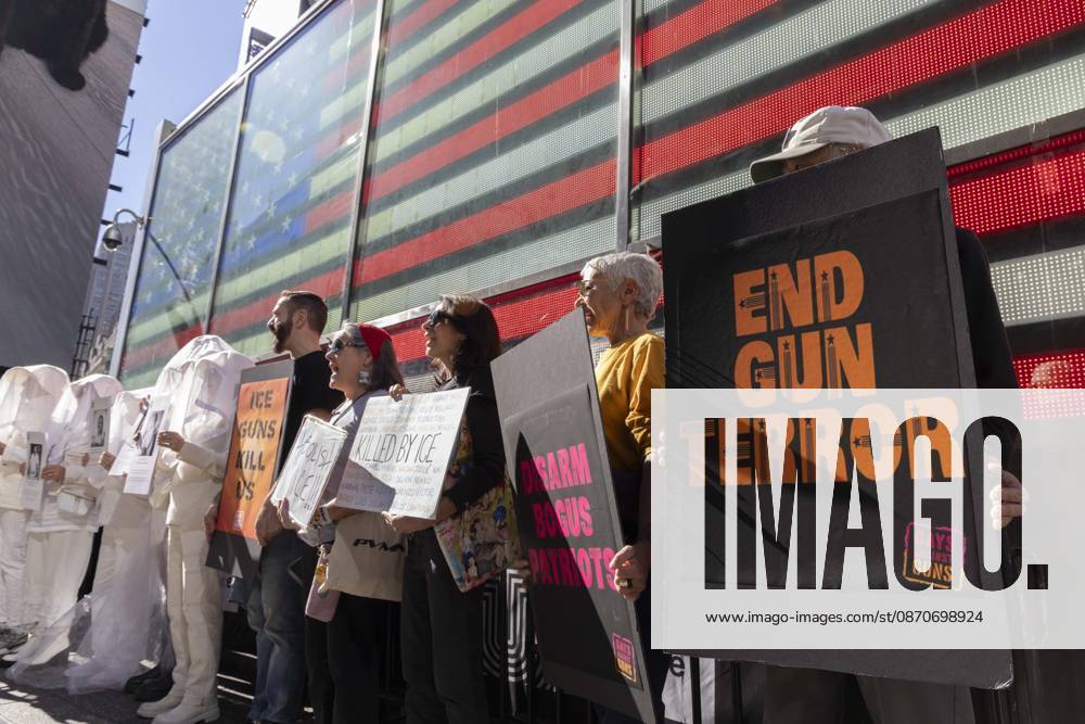 Demonstrators with the anti-gun violence organization Gays Against Guns protest under the Times Square US Army Recruiting Station LED American flag to denounce U.S. Immigration and Customs Enforcement (ICE) and President Trump s immigrant detention and mass deportation policies. People dressed in white shrouds are Human Beings, memorializing people killed by gun violence from Federal immigration agents by holding signs with their images and names. Protesters chant holding signs that read ICE GUNS KILL US DISARM BOGUS PATRIOTS END GUN TERROR. New York USA - ZUMAr174 20261025_znp_r174_002